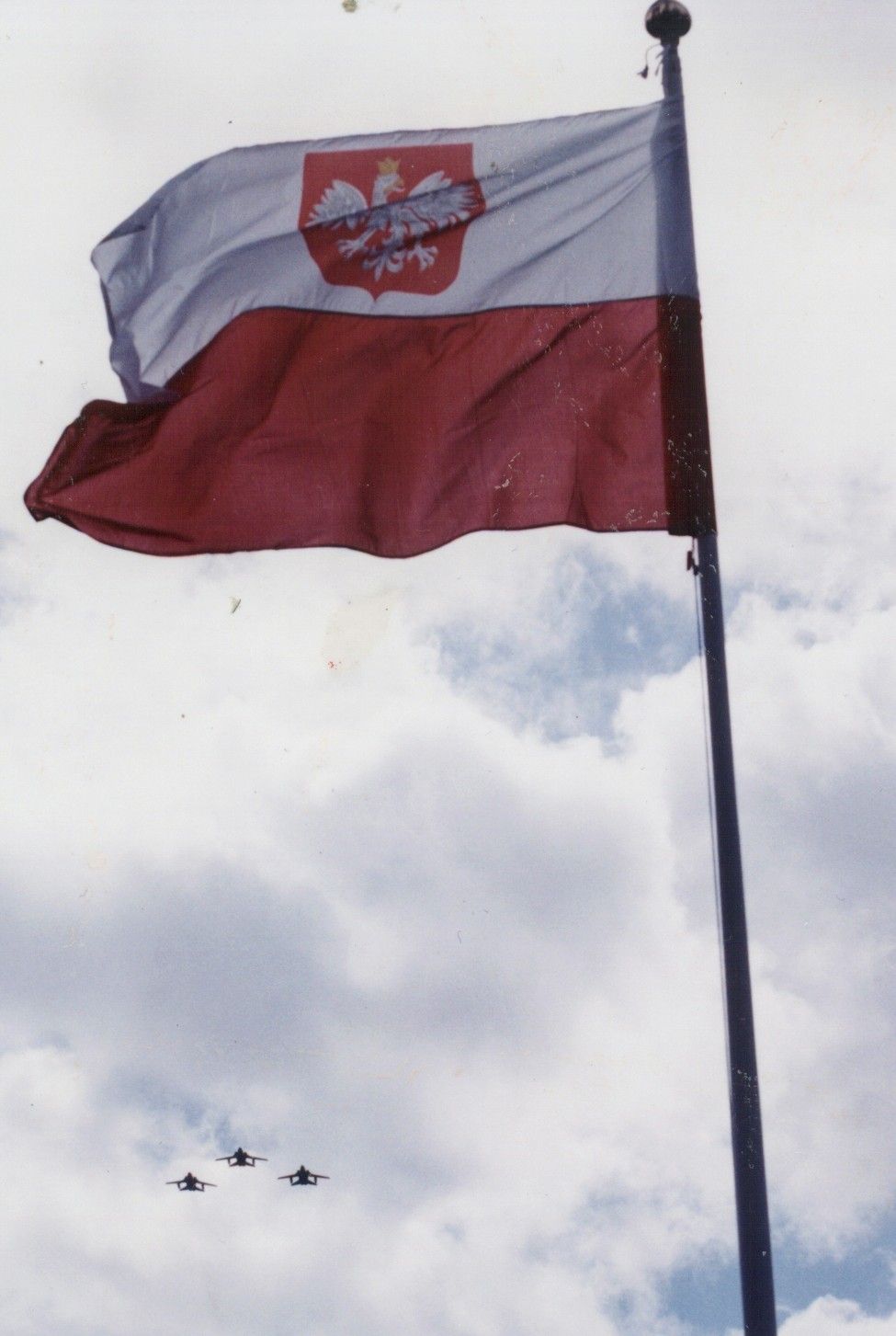 Three RAF F3 Tornado jet fighter aircraft fly in dedicated formation above the Polish Tribute's National flag.
